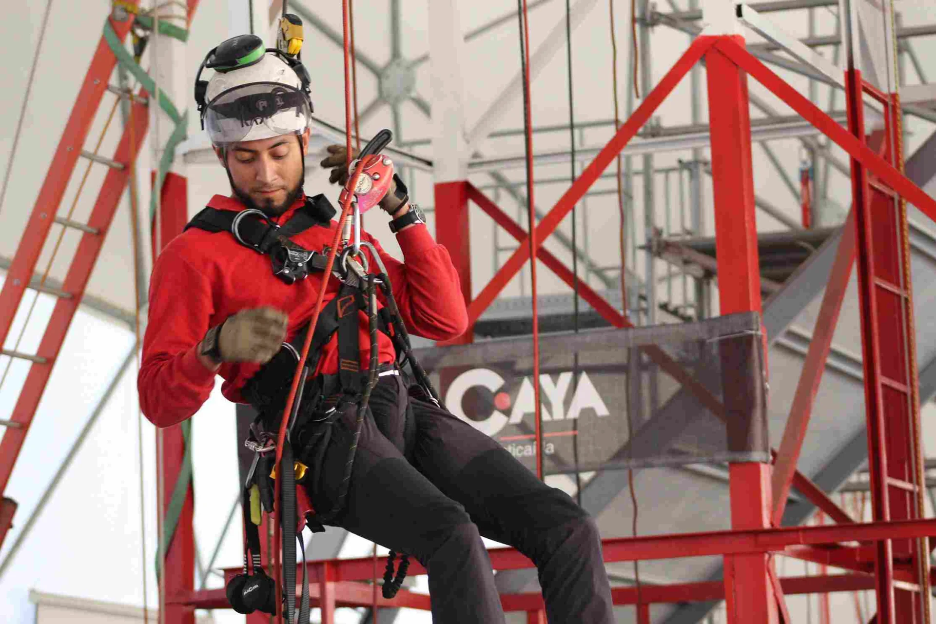 técnico con arnés de seguridad realizando trabajo en altura en estructura industrial Macaya Safety